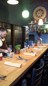 Inside of Farm Spirit, at seating. Your placecards have your name from the reservation to indicate your seats. Chef Aaron Adams is working on the prep of the second course.