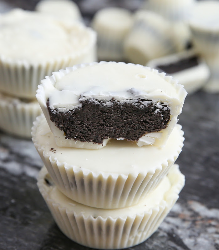 photo of a stack of three Cookies and Cream Chocolate Candy Cups with the top one cut in half to show the inside