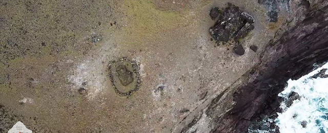 Aerial view of a moai statue on Easter Island that was toppled years ago. Residents surrounded it with stones to protect it from tourists. But the sea is the larger threat. The statue lies only yards from a sea cliff that is rapidly eroding. Photo: Josh Haner / The New York Times