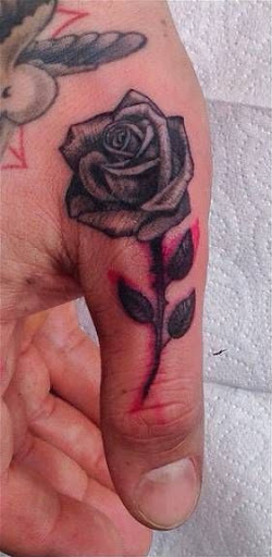 Colored rose tattoo on upper left thumb