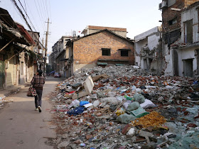 woman walking by the rubble of demolished buildings near Beizheng Street in Changsha