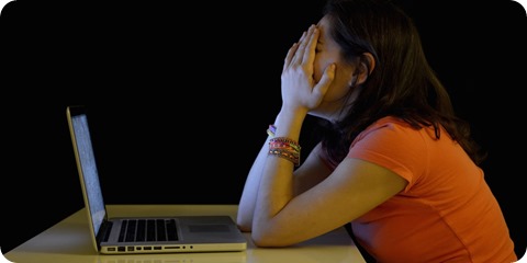 Young student woman alone at desk with computer crying desperate suffering