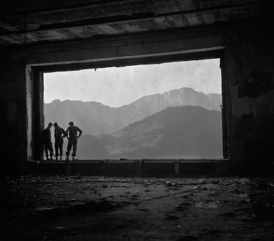 black and wihite photo of US GIs standing in open window of Hitler's retreat in Germany, 1945