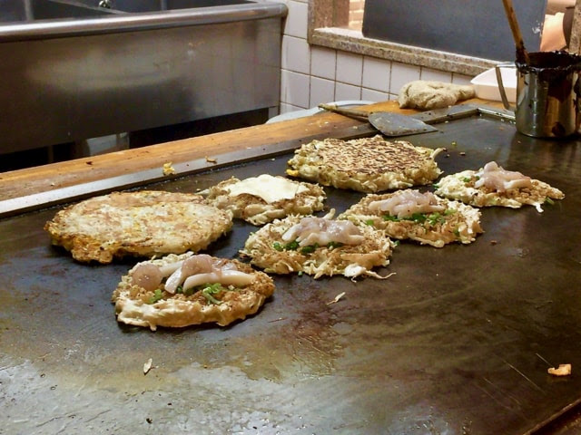 鉄板の上で焼かれてるお好み焼き