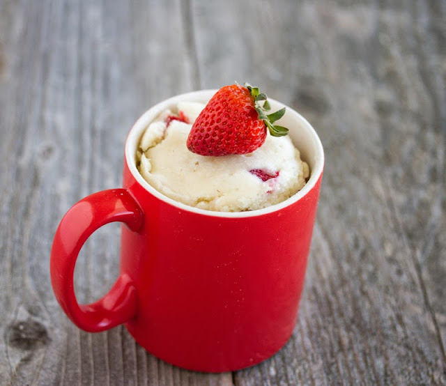 photo of Strawberries and Cream Mug Cake with a fresh strawberry on top