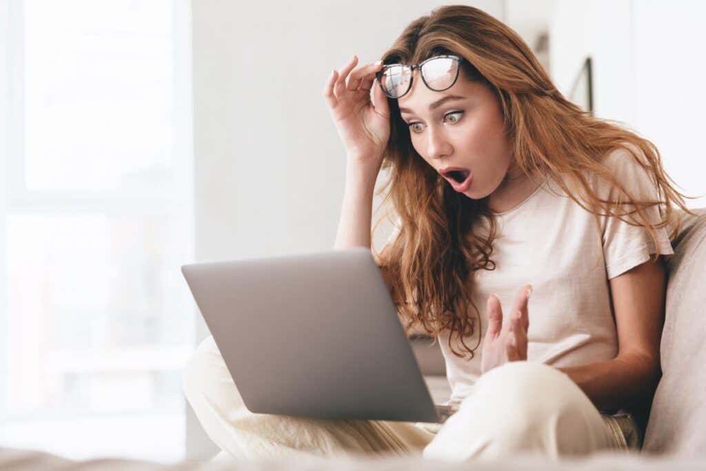 donna che guarda scioccata da ciò che sta vedendo sul suo computer