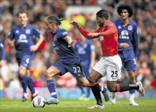 DRIVING FORCE: Everton's Steven Pienaar competes with Manchester United's Antonio Valencia during their Premiership match at Old Trafford in Manchester, England, on Sunday. Photo: Getty Images