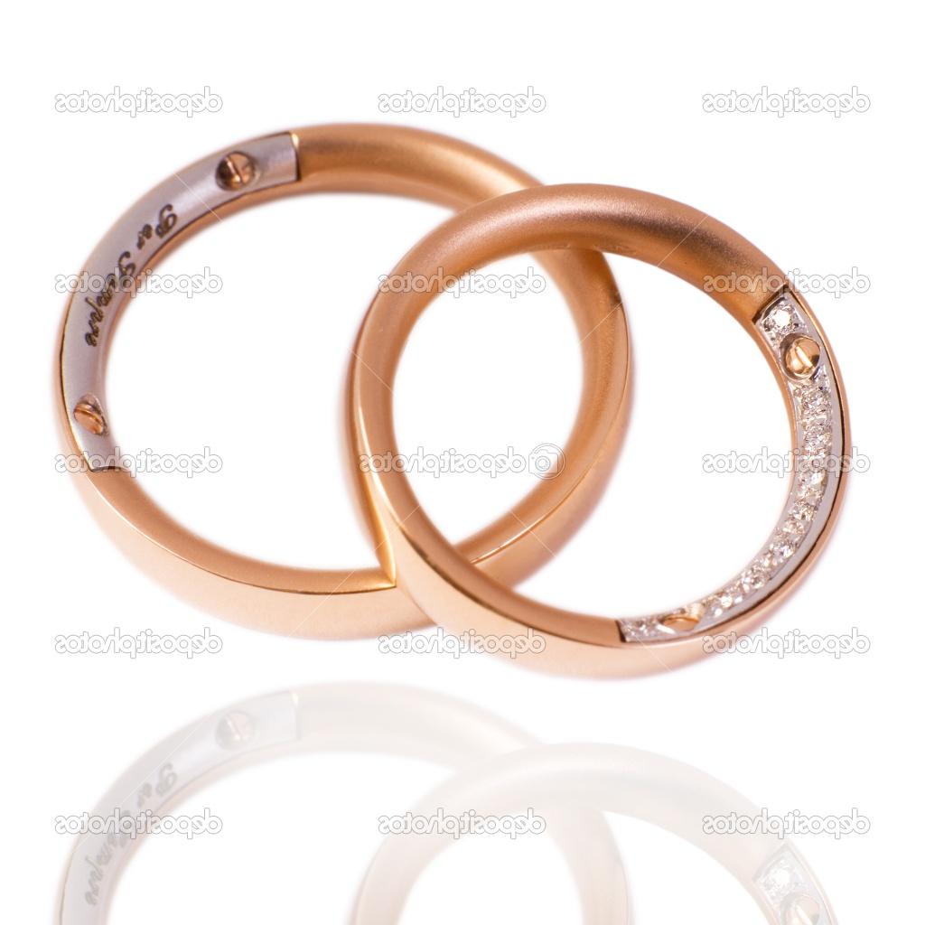 His and hers golden wedding bands, with diamonds. On a white background with