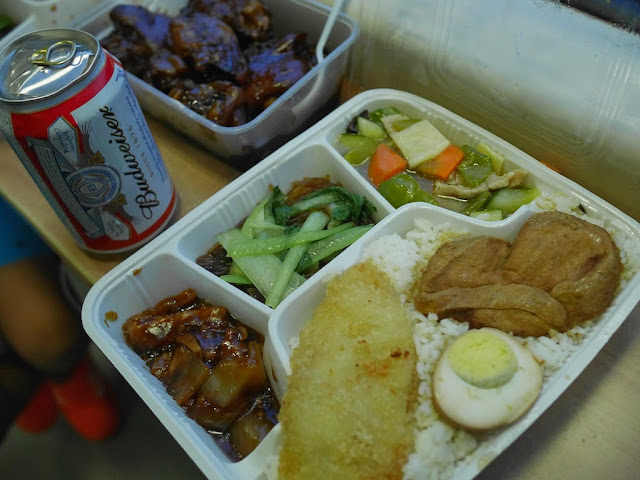 can of American Budweiser next to a prepared meal purchased on a train in China