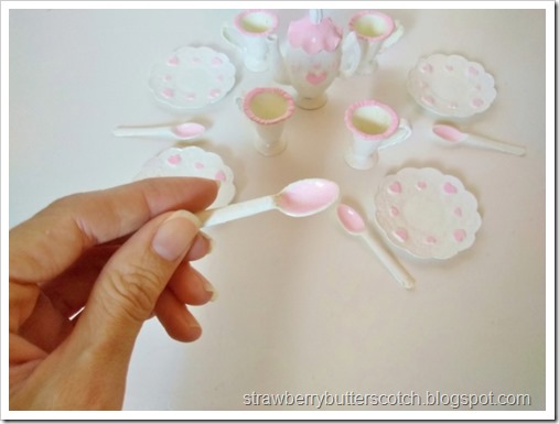 A close up of one of the spoons.  It is painted white with pink on the inside.