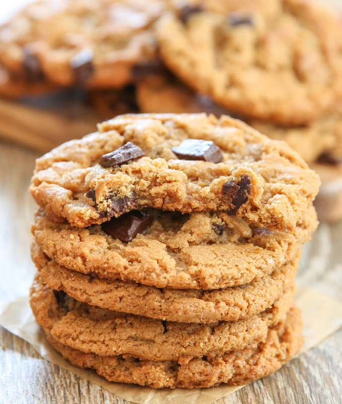 five flourless almond butter cookies in a stack with a bite taken out of the top one