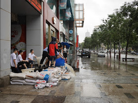 men dumping out water from a flooded underground garage