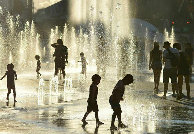 Children play in the water fountains at the Place des Arts in Montreal, Canada on a hot summer day 3 July 2018. Photo: Eva Hambach / AFP / Getty Images