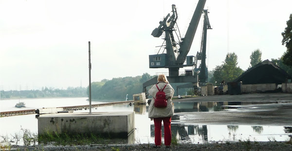 Hafen: Besucherin blickt auf Rhein und Kran.