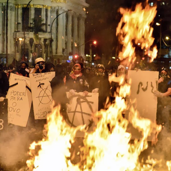 Masked demonstrators burn trash outside the City Hall, following a peaceful teachers protest demanding better working conditions and against police beating.