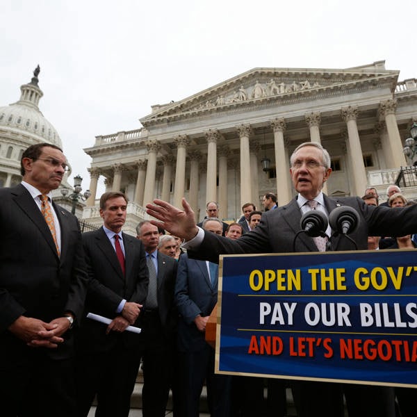 U.S. Senate Majority Leader Harry Reid (D-NV) gathers with other Democratic Party senate members and Washington D.C. Mayor Vincent Gray (L) on the steps of the U.S. Capitol in Washington.