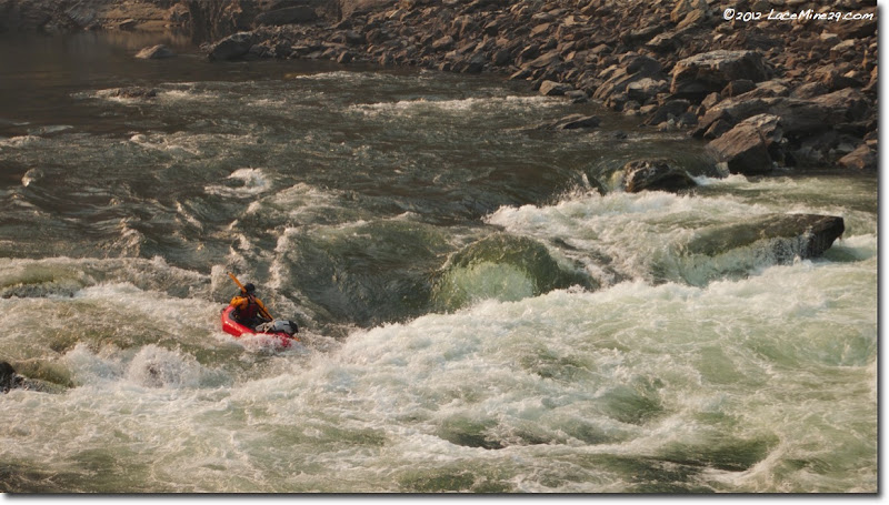 Ultralight packrafter paddling through rapids