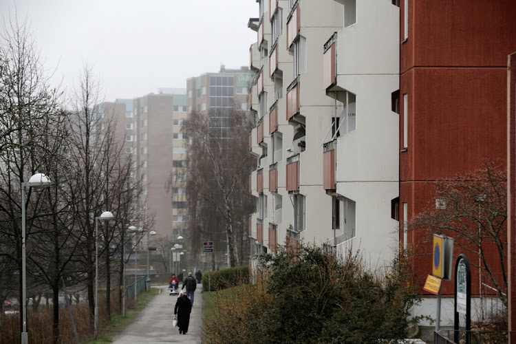 People walk past apartment blocks in Stockholm. Picture: INTS KALNINS/REUTERS