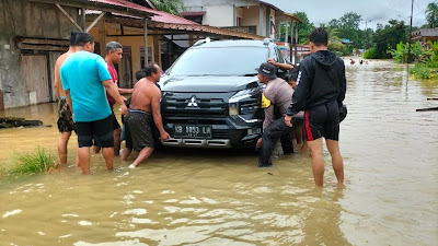 Bhabinkamtibmas Polsek Air Besar Berjibaku Evakuasi Warga Korban Banjir Bandang