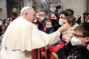 Pope Francis greets people as he arrives for the weekly general audience at the Paul VI Hall at the Vatican, March 16, 2022. 