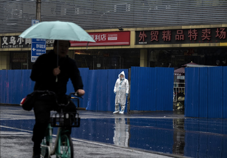 An epidemic control worker wears protective equipment as he guards a fenced off area of a locked down community on November 11, 2022 in Beijing, China. Picture: Kevin Frayer/Getty Images