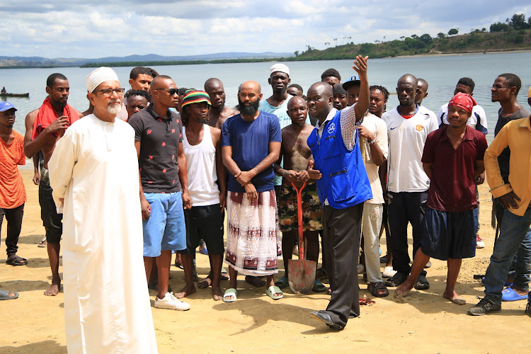 Muhuri officer Francis Auma with disgruntled Tudor Four residents at Tudor Beach on Wednesday.