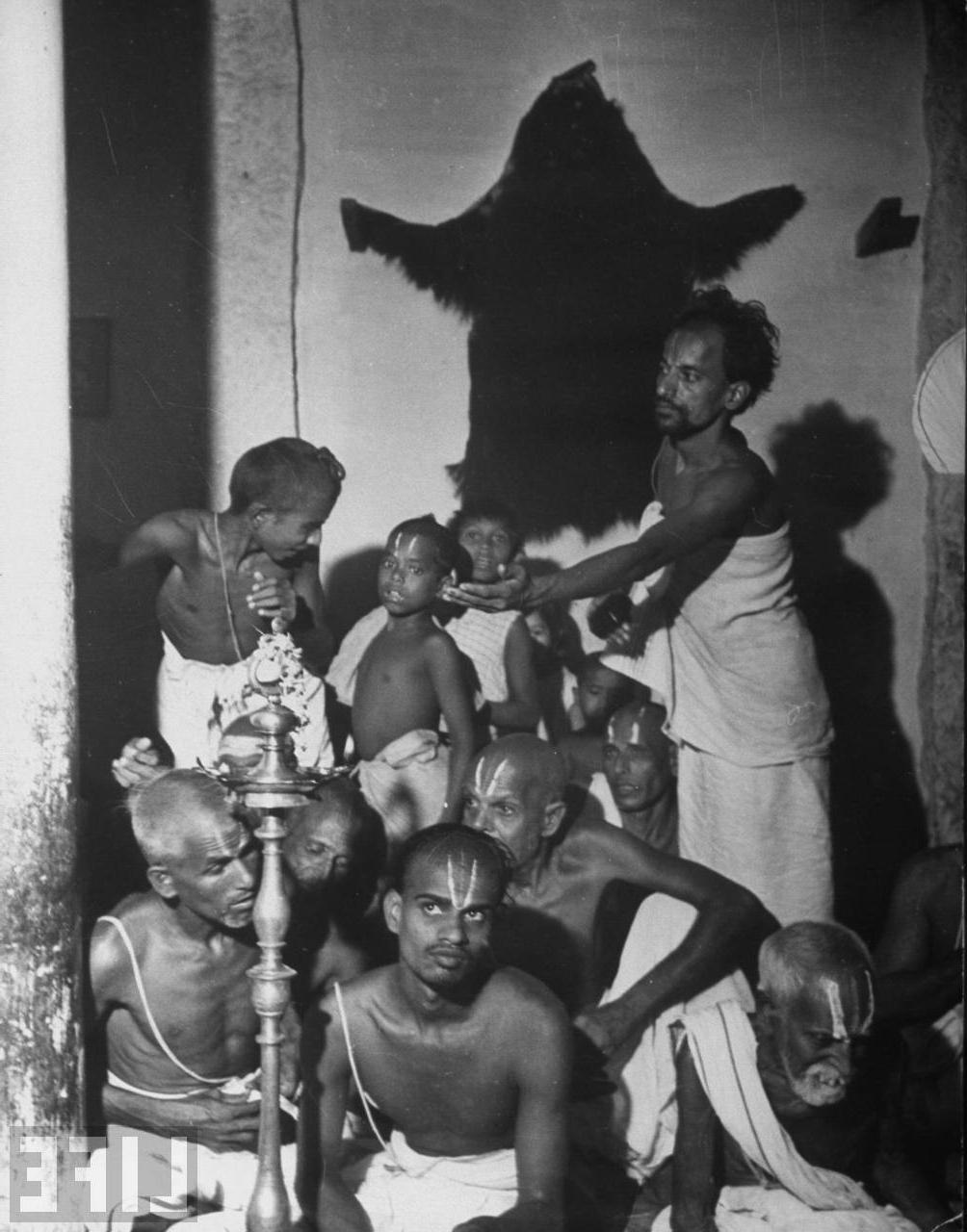 Hindu priest passing a bowl of