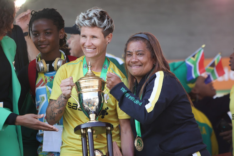 Banyana Banyana defender Janine van Wyk poses with head coach Desiree Ellis at OR Tambo International Airport on July 26 2022 after the team was crowned champions at the 2022 Women's Africa Cup of Nations in Morocco.