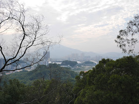 view of mountains, buildings, and a stadium.