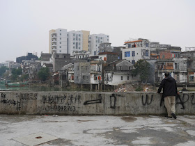 man looking across the river in Yangjiang, China