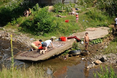 Frauen waschen einen Teppich im Fluss bei Zlatna