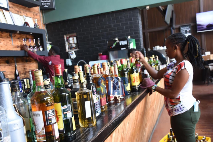 Anita Nyambura a service girl at Zipang bar and restaurant dust alcoholic drinks in preparation of the reopening of bars on September 29, 2020.