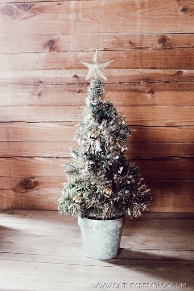 Decorating a small tree for Christmas using a tiny galvanized pot & Dollar Tree ornaments, tinsel & lights!