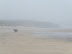 Three people trek along the fog bound sands