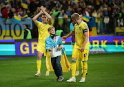 Ukraine's Oleksandr Zinchenko celebrates after qualifying for Euro 2024 as a young fan is seen on the pitch after their Euro 2024 qualifying win against Iceland at Stadion Miejski Wroclaw in Wroclaw, Poland on Tuesday.
