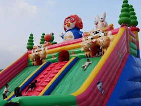 children playing on a large inflated Pororo-themed slide at Donghu Park in Zhuzhou, Hunan