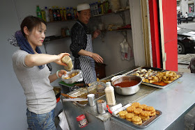 man and woman selling potatoes and other foods in Lanzhou, China