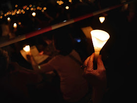 hand holding a candle at the vigil in Victoria Park, Hong Kong, commemorating the anniversary of the Tiananmen Square crackdown