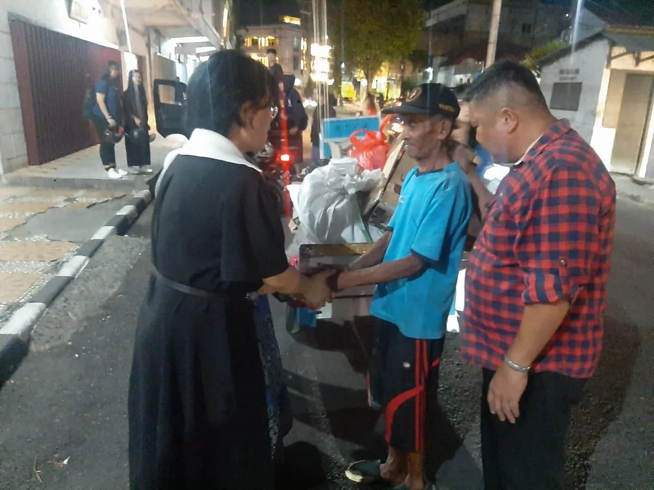 Pendeta Seiyon Park (baju hitam) dan tim mendoakan warga dalam misi pelayanan di Sulawesi Utara. (Foto: Dwi)