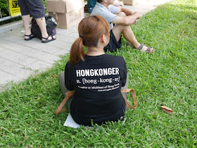 young woman wearing a shirt with the definition of "Hongkonger"