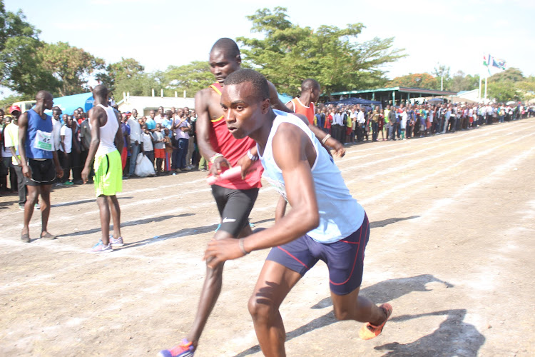 Brian Tinega receives a baton from Pesi Leshoo during the Nyanza secondary schools championships at Homa Bay School