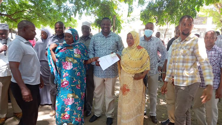 Governor Salim Mvurya gives parents bursary cheque in Tiwi, Kwale county in April 2022.