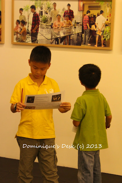 The boys looking at the exhibit while reading the questions