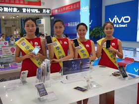 four young women promoting Huawei mobile phones inside a store in Changsha