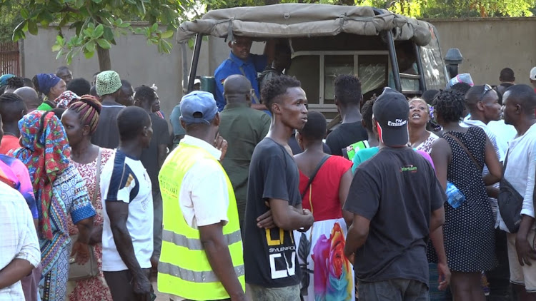 Malindi residents mil around a police vehicle that was carrying some of the victims that were rescued from Shakahola.