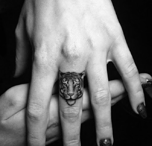 small tiger face tattoo on finger