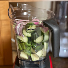 blender filled with onion, peppers, cucumber and zucchini