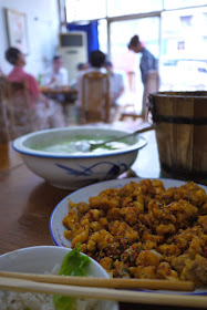 rabbit meat dish in front of a wooden bucket of rice in Zigong, Sichuan