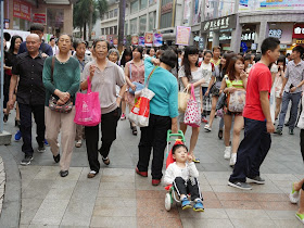 woman pulling a stroller cart with a young boy