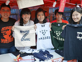 college students hold shirts with a variety of messages including "From the Masses" and "Drive HIm Away Reclaim Our Gov"